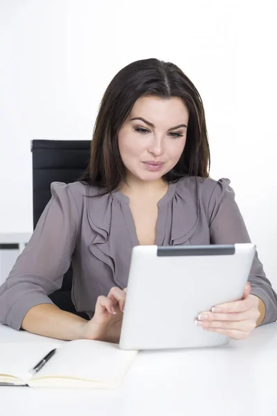 Portret van een vrouw in grijs met een tablet — Stockfoto