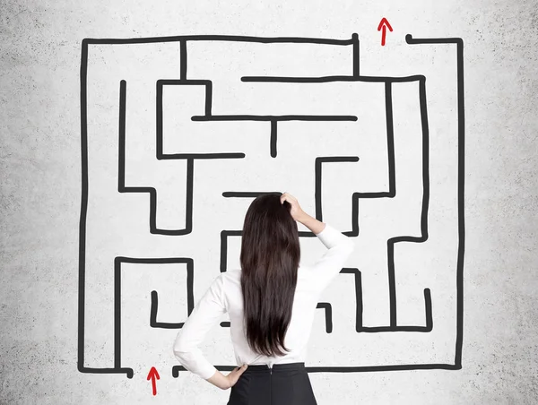 Rear view of a woman looking at a square maze — Stock Photo, Image