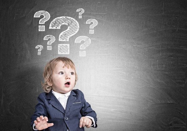 Мальчик и вопросительные знаки на доске

