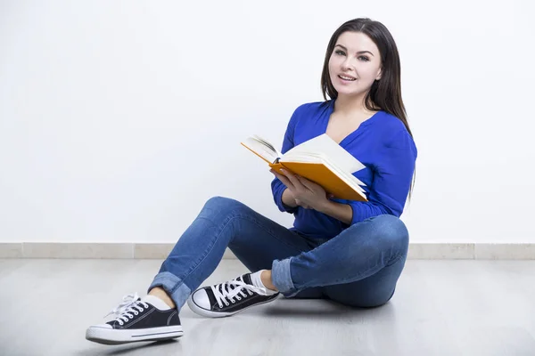 Junges Mädchen in Jeans mit einem Buch — Stockfoto