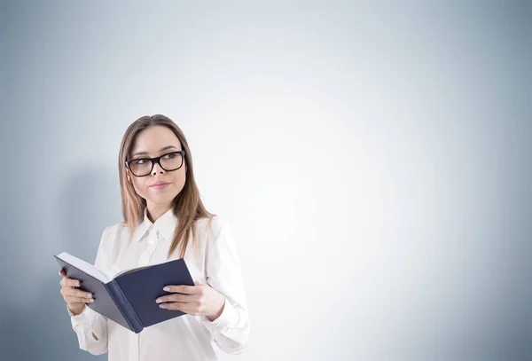 Femme souriante dans des lunettes lisant un livre — Photo