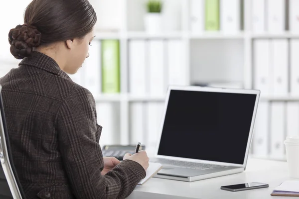 Bakifrån av kvinna med en laptop i office — Stockfoto