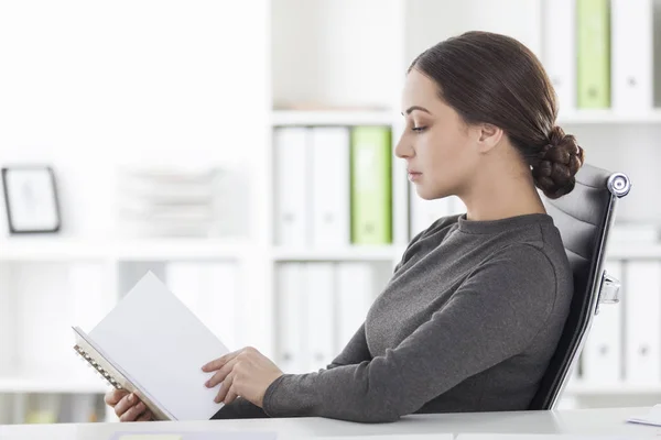 Sidovy av kvinna i grå läsning i office — Stockfoto