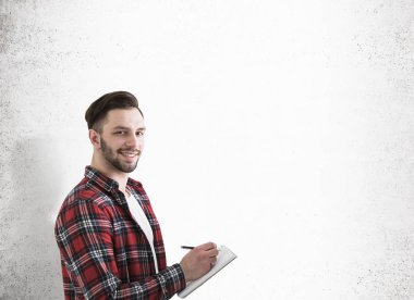 Hipster adam beton duvar yakınındaki bir defter ile