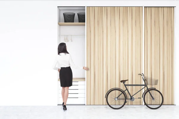 Woman near a built in wadrobe in a room with bike — Stock Photo, Image