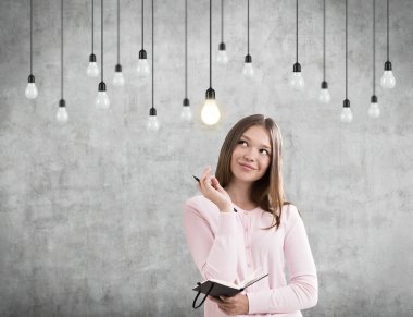 Kadın defter ve asılı ampuller, beton ile