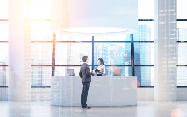 İşadamı yakınındaki yuvarlak bir resepsiyon masası, tonda