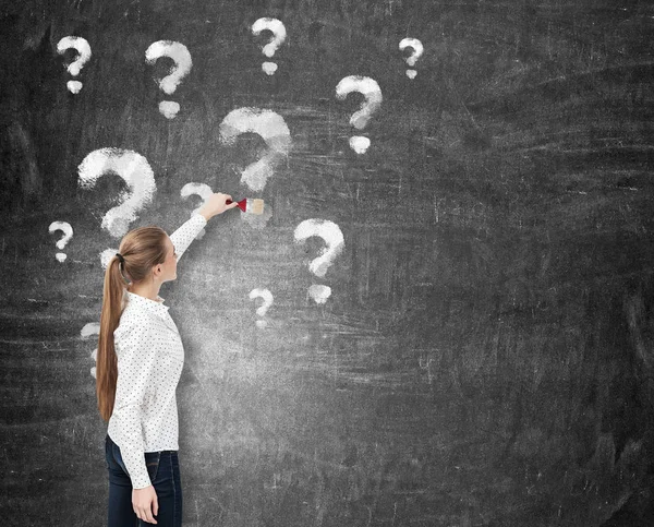 Blond woman drawing question marks — Stock Photo, Image