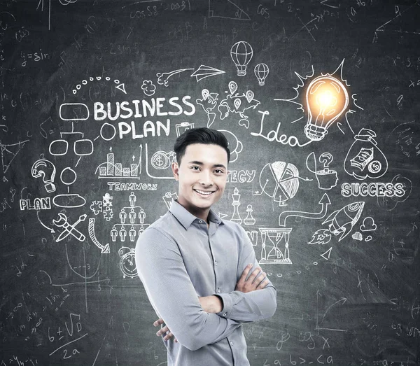 Aziatisch mens en business plan op blackboard — Stockfoto