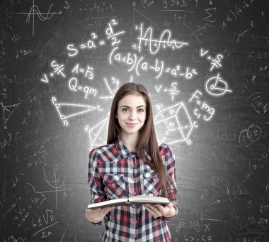 Yazı tahtası üzerinde formüller yakınındaki açık kitap kızla