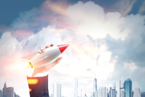 Man with rocket and a clowdy city — Stock Photo, Image