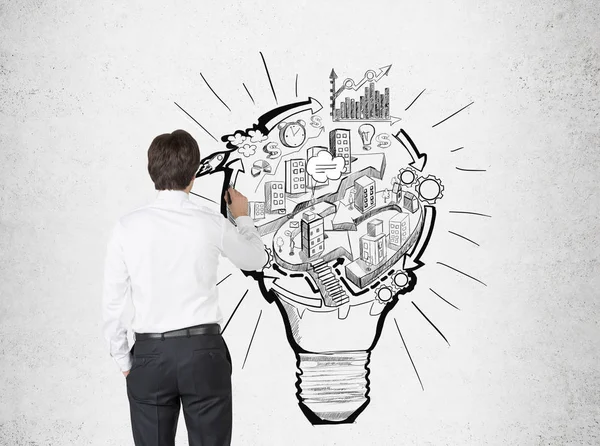 Businessman drawing a light bulb city — Stock Photo, Image