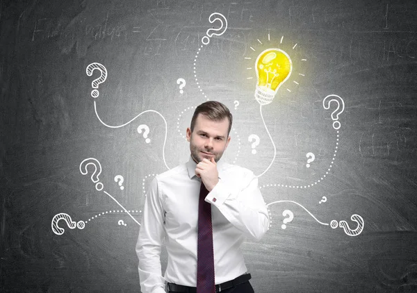 Pensive businessman, bulb and questions — Stock Photo, Image