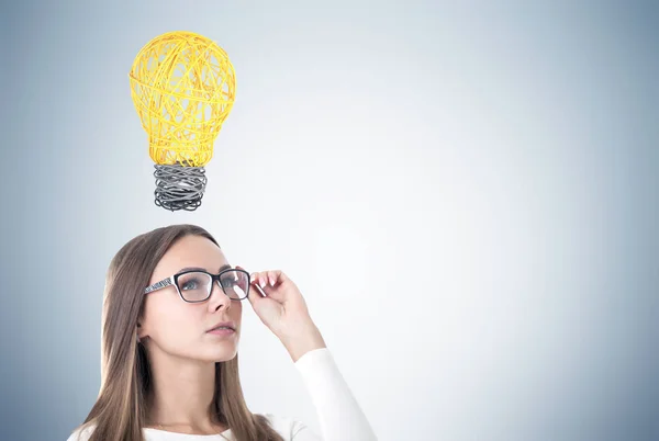 Frau mit Brille und Glühbirne — Stockfoto