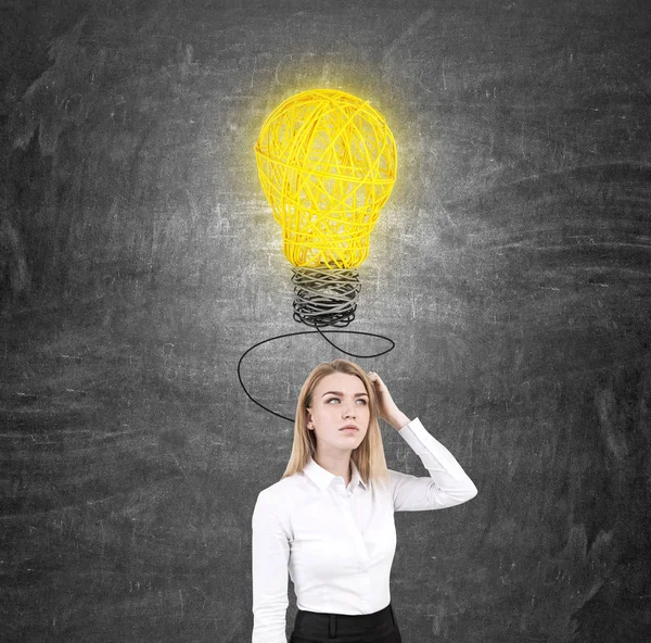 Donna graffiando testa e lampadina — Foto Stock