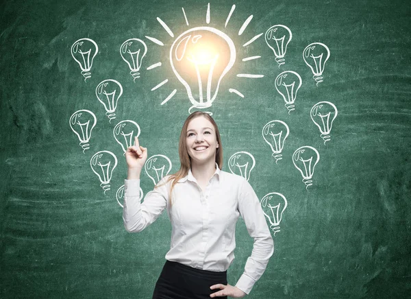 Positive blond girl and many light bulbs — Stock Photo, Image