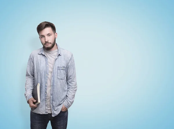 Guy in a jeans shirt, blue wall — Stock Photo, Image