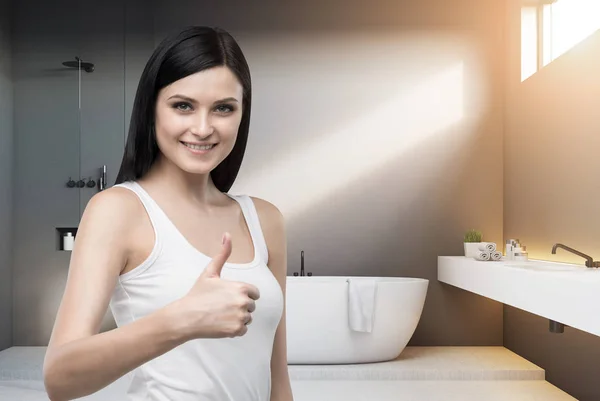 Thumb up woman in bathroom