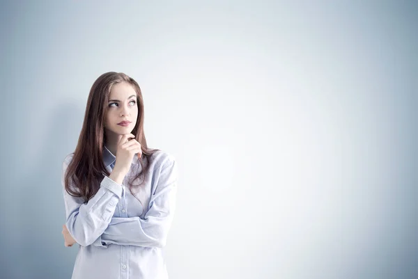 Mujer pensativa cerca de la pared gris — Foto de Stock