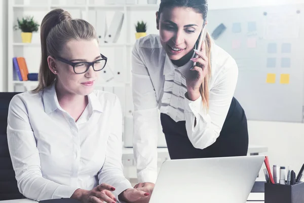 Frau am Telefon und ihr Kollege im Büro — Stockfoto