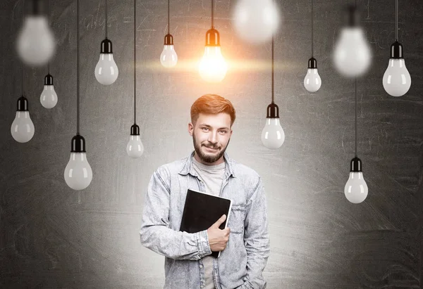 Hombre con cuaderno y muchas bombillas —  Fotos de Stock