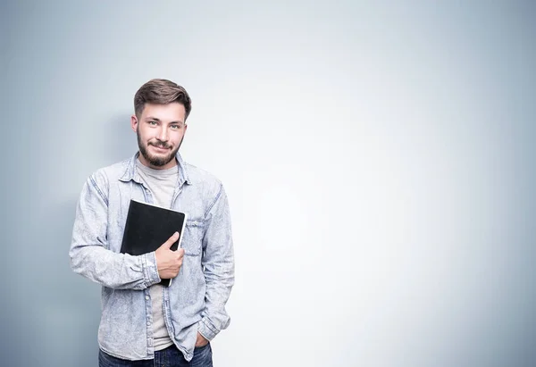 Man met laptop in de buurt van grijze muur — Stockfoto