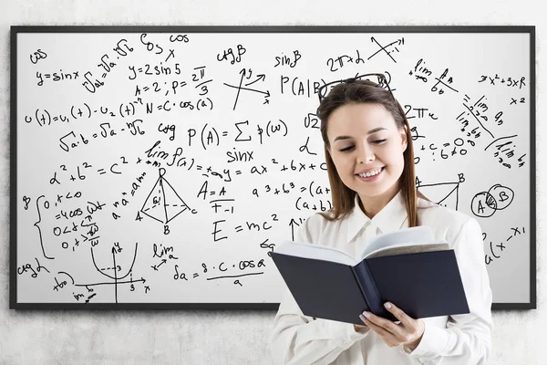 Formeln auf Whiteboard und Frau mit Buch — Stockfoto