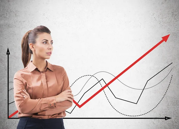 Woman in brown looking at red graph — Stock Photo, Image