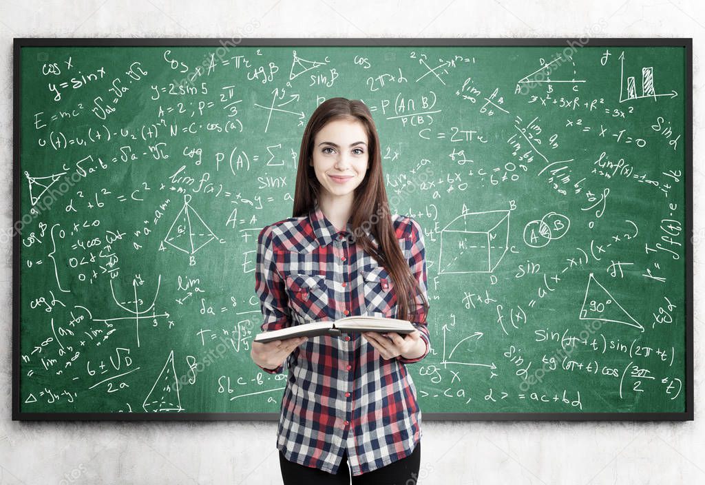 Teen girl with book near blackboard, formulas