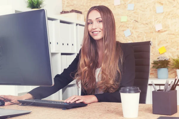 Mujer de negocios sonriente en una computadora —  Fotos de Stock