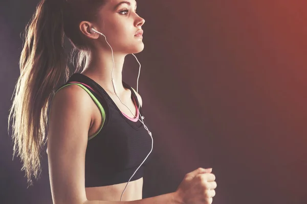 Sportswoman in tank top with earphones