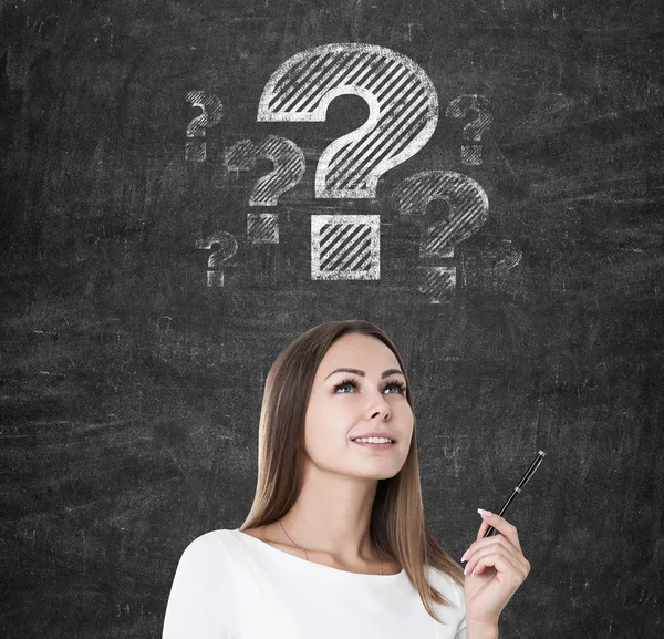 Mujer inspirada con una pluma y signos de interrogación — Foto de Stock