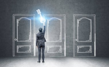 Çizilmiş kapılar yakınındaki dev bir tuşuna basılı tutarak işadamı