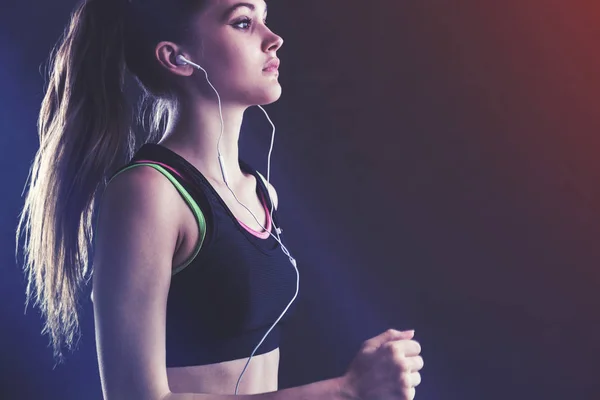 Deportiva en camiseta con auriculares tonificados — Foto de Stock