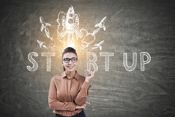 Young woman with glasses pointing at start up — Stock Photo, Image