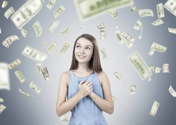 Dreamy teen girl, hands near heart, dollar rain — Stock Photo, Image