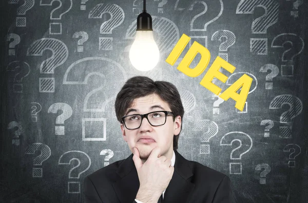 Skeptical young businessman and an idea — Stock Photo, Image