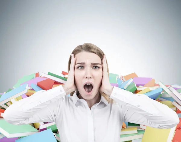 Blond affärskvinna skrikande, högar av böcker — Stockfoto
