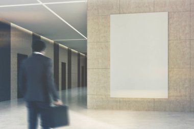 Ofis veya otel lobisinde bir posteri ile işadamı