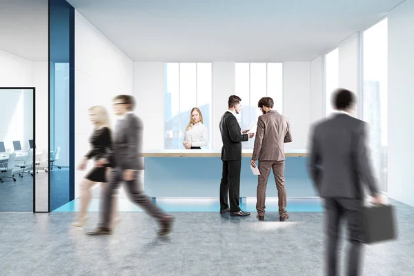 Blue reception counter in white office, people