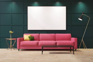 Yeşil bir oturma odasında pembe kanepe