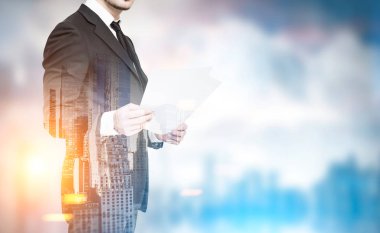 İşadamı ile kağıtları bulanık bir şehirde