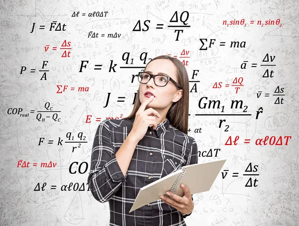 Geek flicka i glasögon med anteckningsbok och formler — Stockfoto