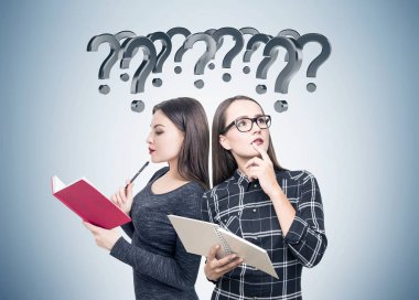 Kitaplar, soru işaretleri ile iki öğrenci