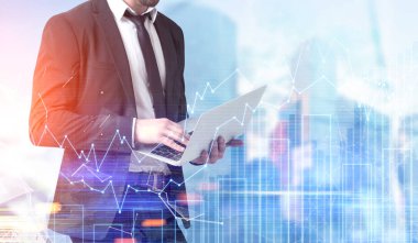 İşadamı ile bir dizüstü bilgisayar, grafikler şehir