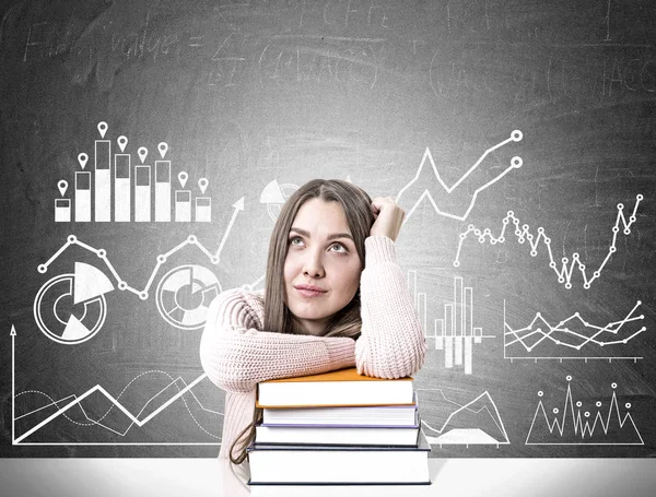 Dreamy student with a pile of books, graphs — Stock Photo, Image