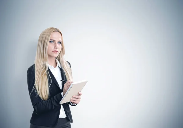 Portrait of a blond woman with a copybook, gray — Stock Photo, Image