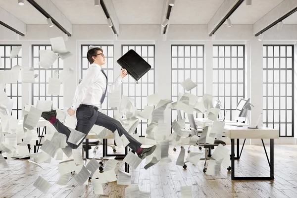 Omul de afaceri sărind într-un birou, hârtii — Fotografie, imagine de stoc
