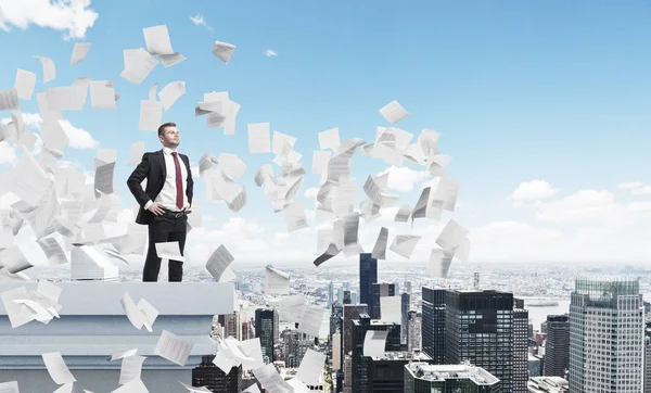 Confident businessman on a roof, papers — Stock Photo, Image