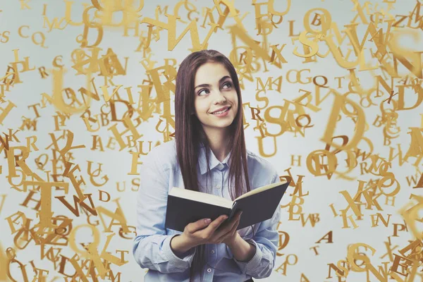 Весела дівчина-підліток з книгою, золотими літерами — стокове фото